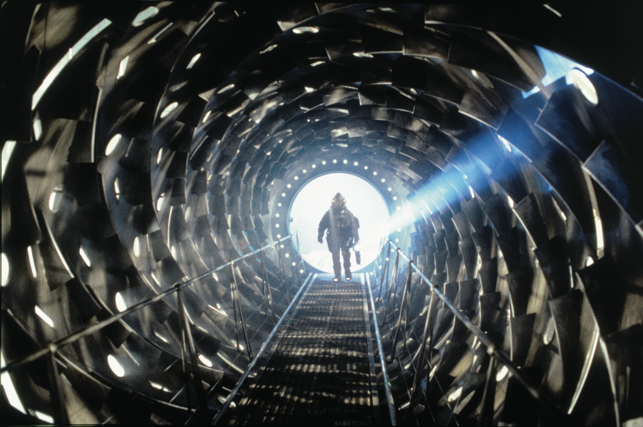 event horizon (1997) promotional image from paramount pictures shows a space-suited person at the end of a long cylindrical tunnel with sharp, shining edges surrounding them... as though they're going into a giant throat of a cosmic beast... Cool (and kinda scary). Bright light at the end of this tunnel.